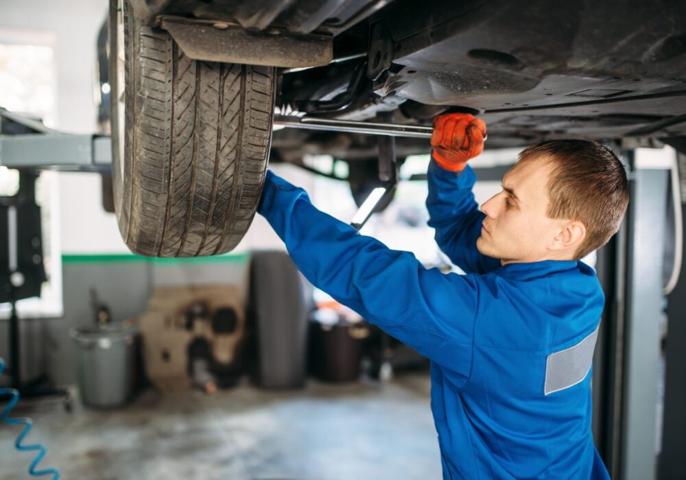 Mechanic repairs the suspension, car on the lift