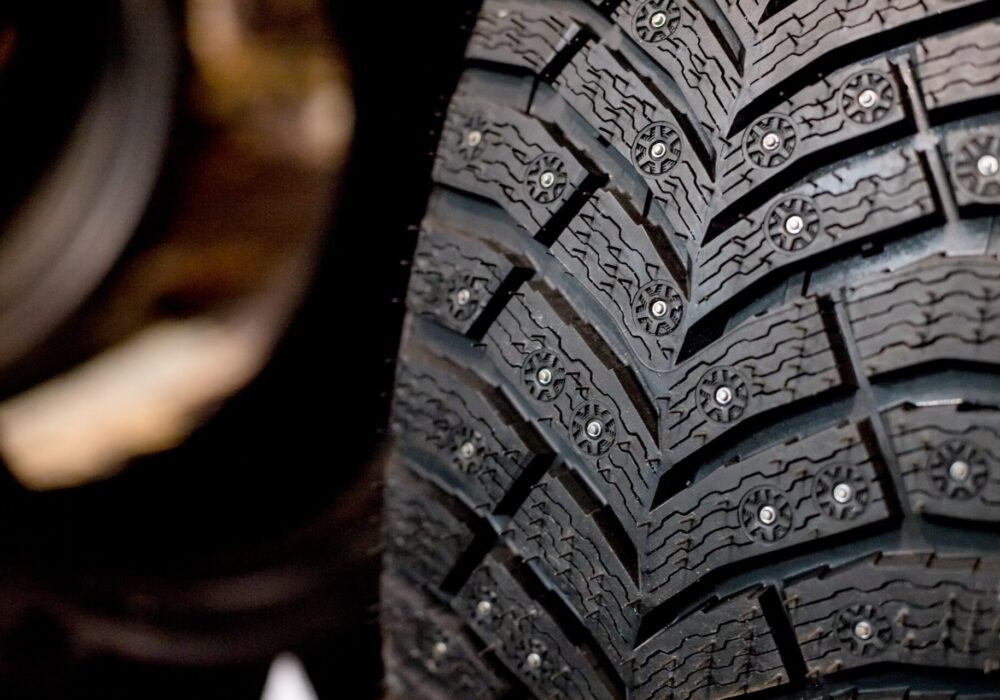 Winter Car tires with snow close-up wheel profile structure on black background.Car tires mature